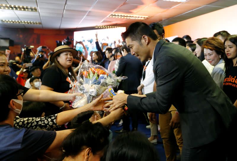 Supporters give flowers to Future Forward Party leader Thanathorn Juangroongruangkit as he arrives to give a speech, at the party's headquarters in Bangkok