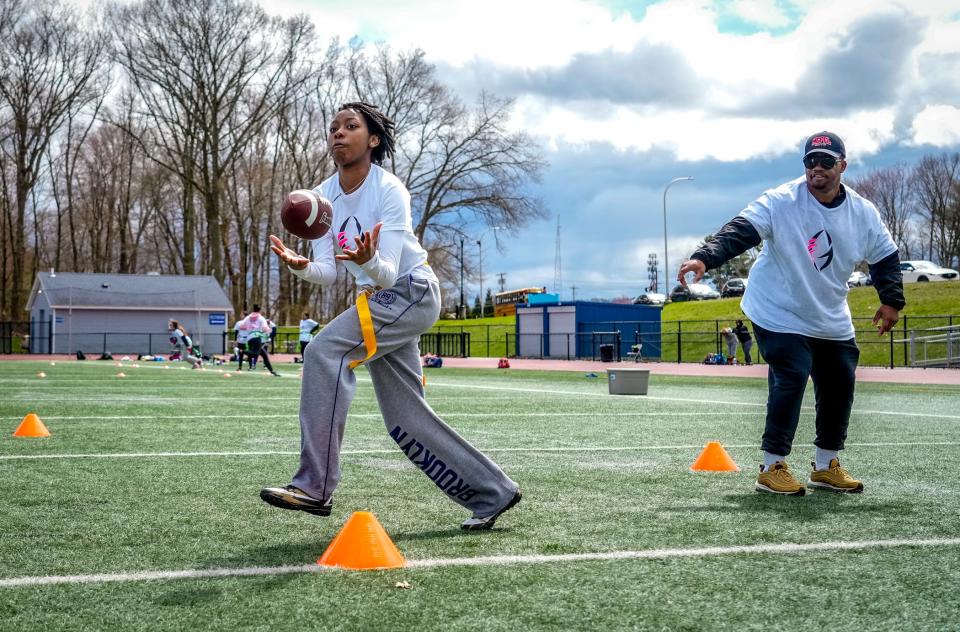 Jumella Thornton of Central Falls catches a pass during Gridiron Girls flag football camp at Johnston High School. Camp coach Terrell Patterson runs the drill.