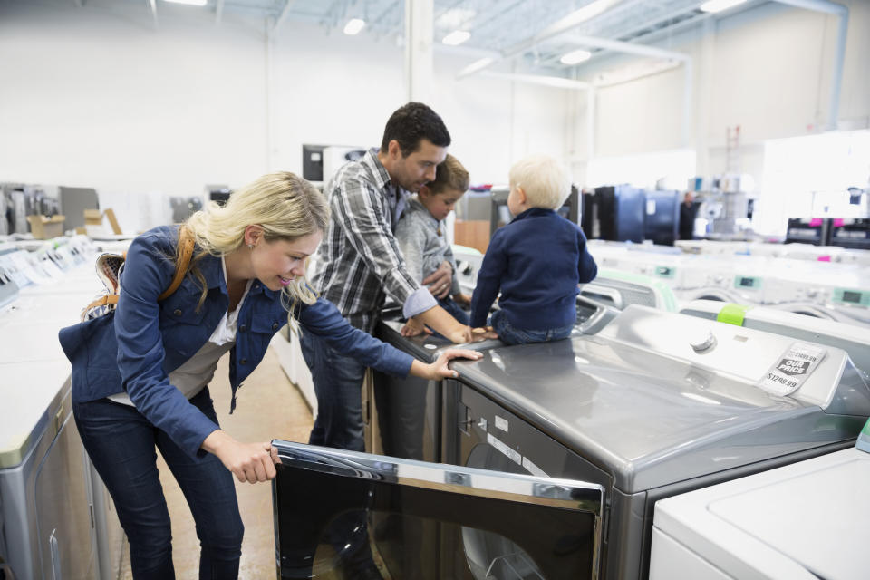 Young family shopping for clothes washer in appliance store (Photo: Hero Images via Getty Images)