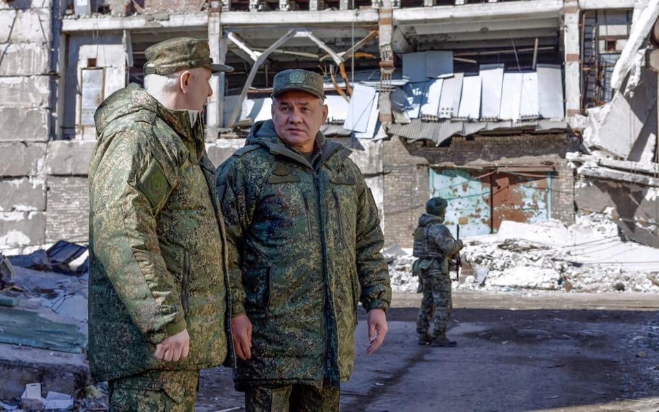 Sergei Shoigu, centre, inspects the Vostok group of Russian troops at an undisclosed location - AP