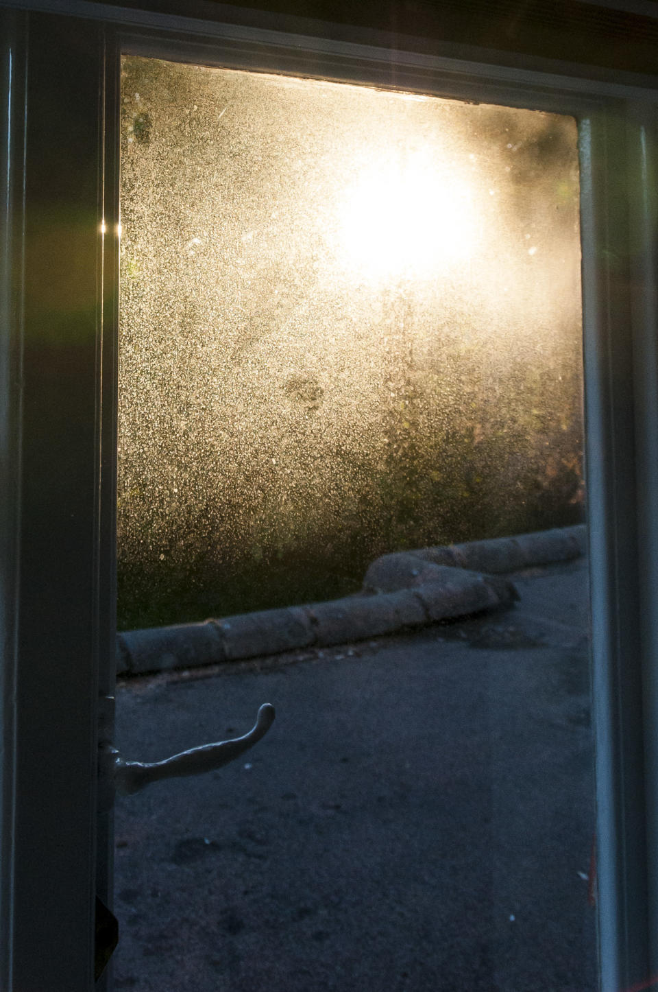 A dirty window with sunset light puring through illuminating the dirt