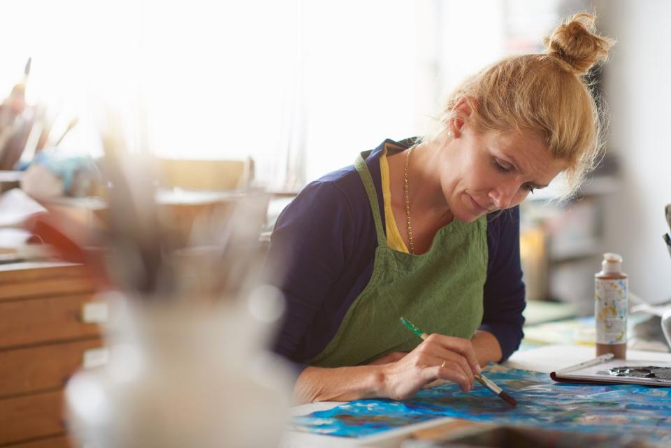 mature female artist working in her studio