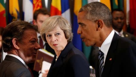 British Prime Minister Theresa May looks over toward U.S. President Barack Obama as he greets Colombian President Juan Manuel Santos (L) during the luncheon at the United Nations General Assembly in New York September 20, 2016. REUTERS/Kevin Lamarque