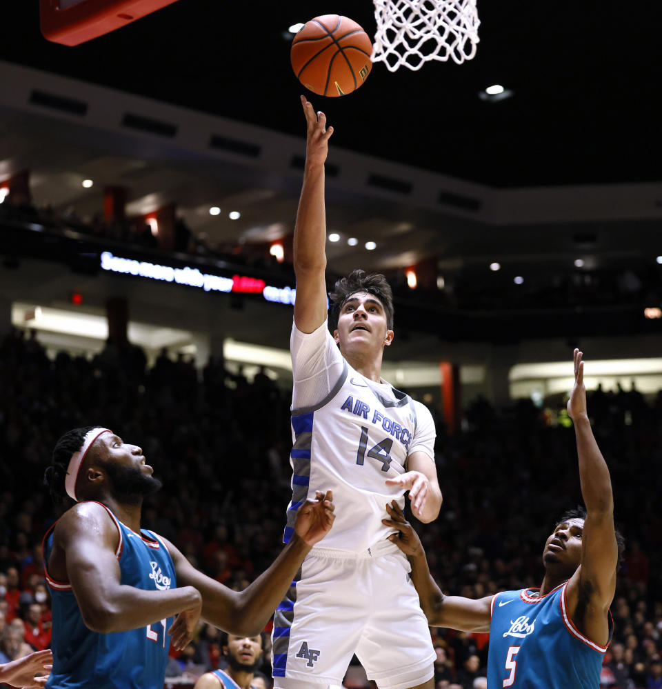 Air Force forward Beau Becker scores on a layup between New Mexico's Morris Udeze, left, and Jamal Mashburn Jr. during the first half of an NCAA college basketball game in Albuquerque, N.M., Friday, Jan. 27, 2023. (AP Photo/Eric Draper)