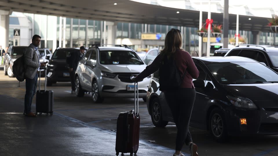 Ride-share passengers wait for their rides outside of Terminal 2 at O'Hare International Airport in Chicago on Dec. 8, 2023. - Trent Sprague/Chicago Tribune/Tribune News Service/Getty Images