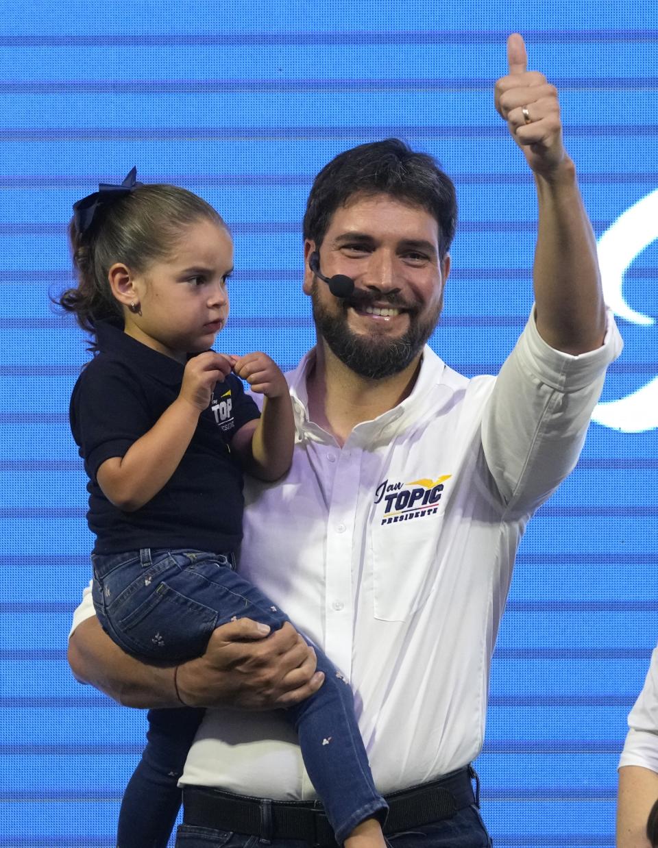 Jan Topic, presidential candidate for the Country Without Fear Coalition, holds his daughter as he smiles during a campaign event ahead of snap elections set for Aug. 20, in Guayaquil, Ecuador, Thursday, Aug. 17, 2023. (AP Photo/Martin Mejia)