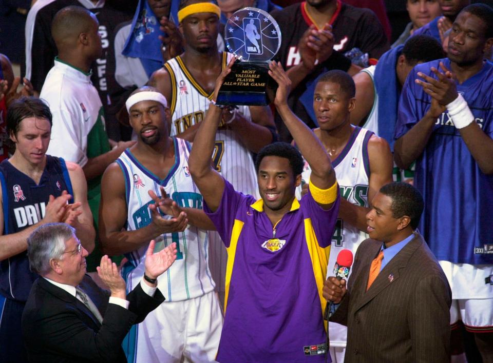 Kobe Bryant holds up his MVP trophy following the 2002 NBA All-Star basketball game in Philadelphia.