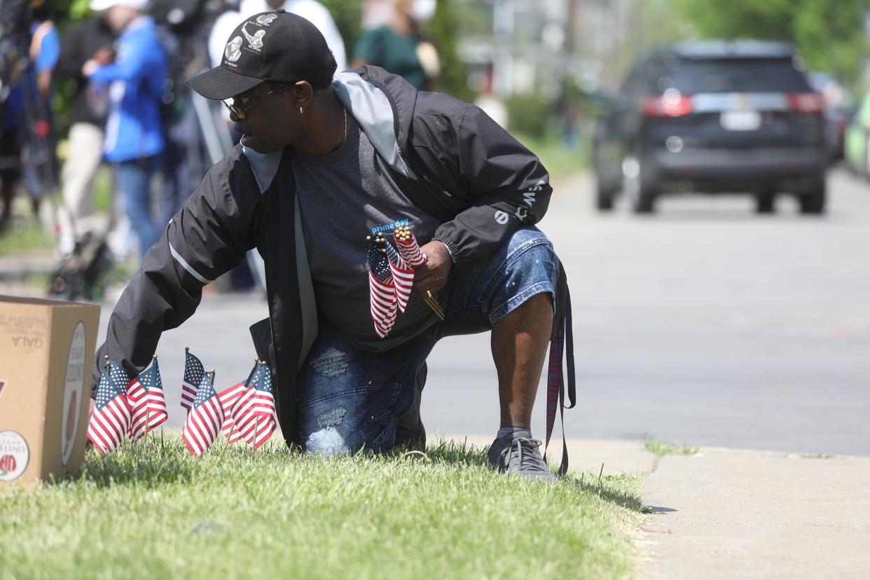 Family and community members come out to pray and be together in the street in front of the Tops Friendly Market on Jefferson Ave., in Buffalo, NY on May 15, 2022. Laverne Dunbar of Buffalo puts several flags around the property of Tops.  10 people were killed and three others injured in a shooting at the Buffalo grocery store on May 14, 2022.  