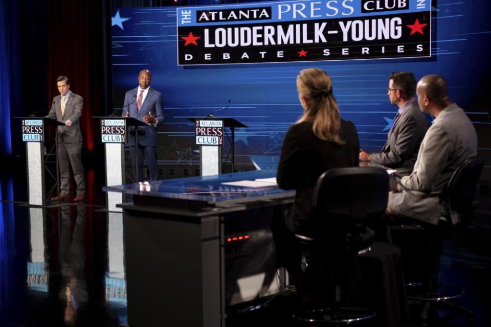 Chase Oliver, left, and Senator Raphael Warnock debate in October.