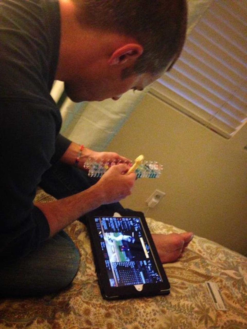 "Dad fixing the rainbow loom while watching the game cast on the iPad."