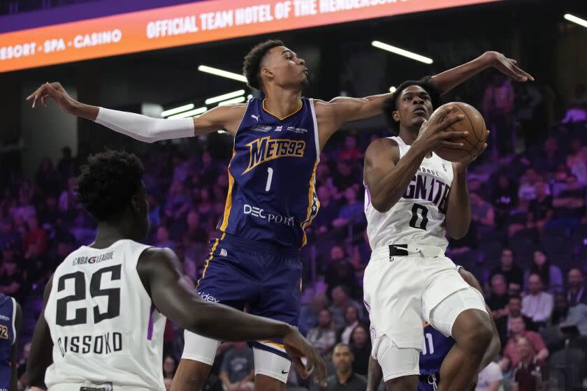 Boulogne-Levallois Metropolitans 92&#39;s Victor Wembanyama, center, guards NBA G League Ignite&#39;s Scoot Henderson, right, during the first half of an exhibition basketball game Tuesday, Oct. 4, 2022, in Henderson, Nev. (AP Photo/John Locher)