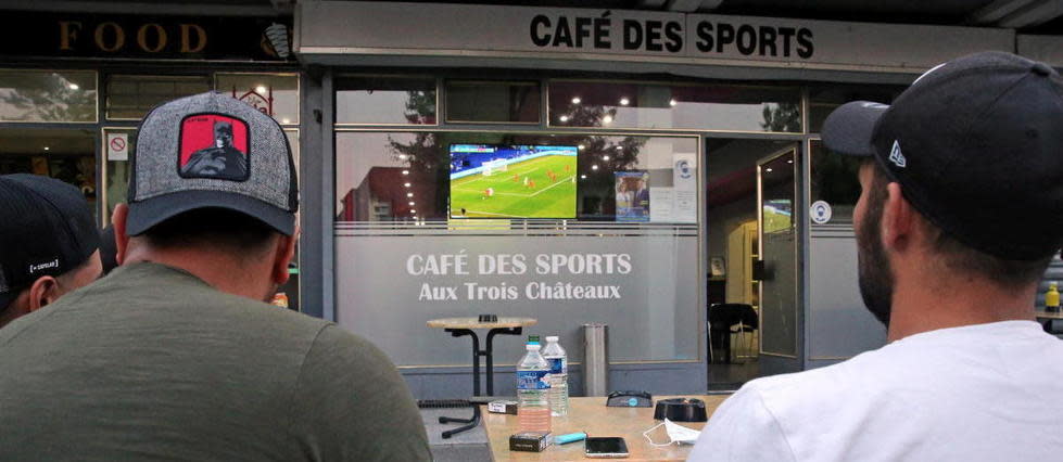 Des fans de foot regardent  le match de l'Euro dans un bar.
