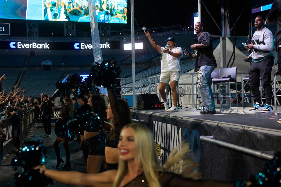 Jacksonville Jaguars long snapper Ross Matiscik (46), running back Travis Etienne Jr. (1) and linebacker Foyesade Oluokun (23) throw t-shirts into the crowd during the Duuval Draft Party Thursday at EverBank Stadium in Jacksonville. More than 12,000 came out to watch the Jaguars choose in the 2024 NFL Draft.