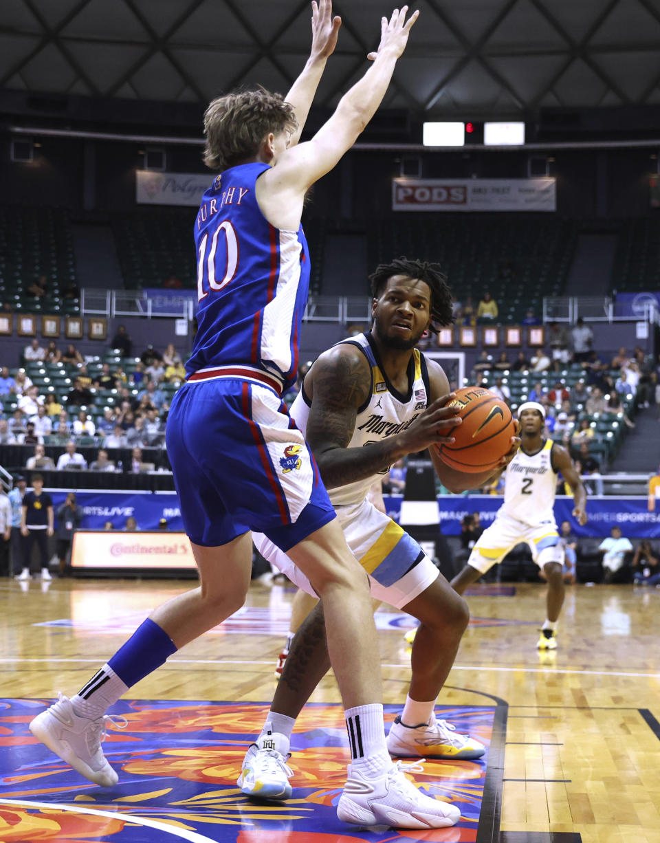 Kansas guard Johnny Furphy (10) guards Marquette forward David Joplin during the first half of an NCAA college basketball game Tuesday, Nov. 21, 2023, in Honolulu. (AP Photo/Marco Garcia)