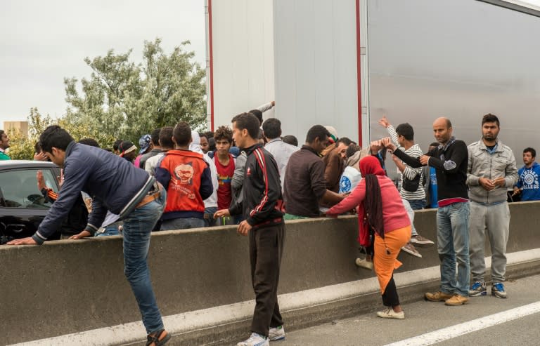 Illegal migrants attempt to climb into lorries heading for England, in the northern French town of Calais, on June 17, 2015