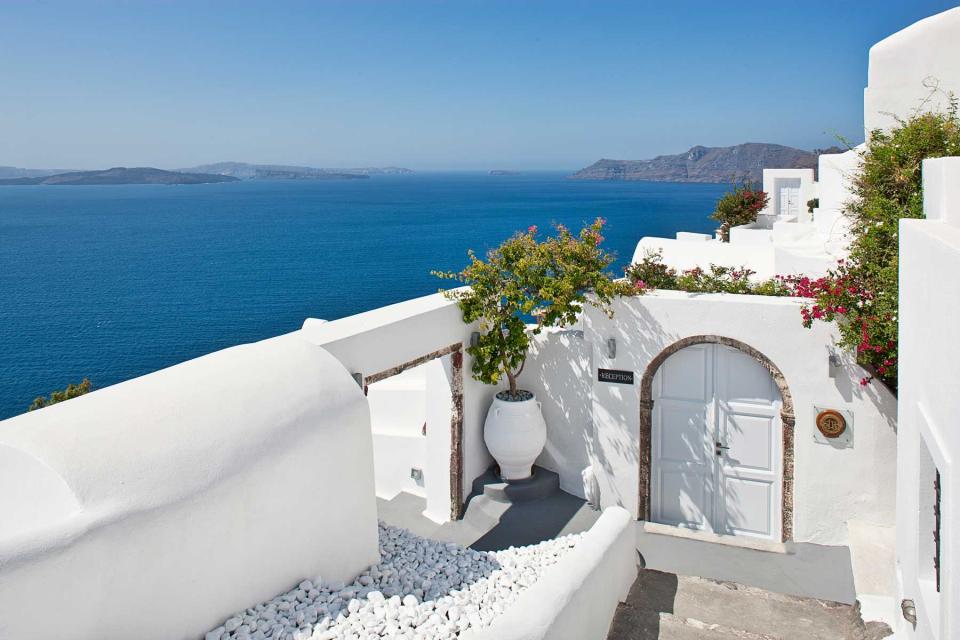 All white entrance to the reception area of the Canaves Oia hotel in Santorini, Greece