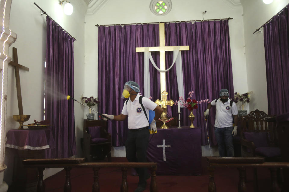 Indian volunteers spray disinfectants at a church in Jammu, India, Sunday, June 7, 2020. India whose coronavirus caseload is fifth highest in the world is Monday reopening places of worship after a period of more than two months lockdown. (AP Photo/Channi Anand)