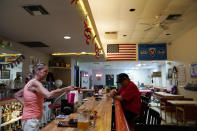 Bartender Rashelle Sundhahl serves a drink at the bar in the Veterans of Foreign Wars building Wednesday, July 14, 2021, in Desert Shores, Calif. The community on the shore of the Salton Sea, California's largest but rapidly shrinking lake, has been through decades of economic stagnation. Now, it's at the forefront of efforts to make the U.S. a major global producer of lithium, the ultralight metal used in rechargeable batteries. (AP Photo/Marcio Jose Sanchez)