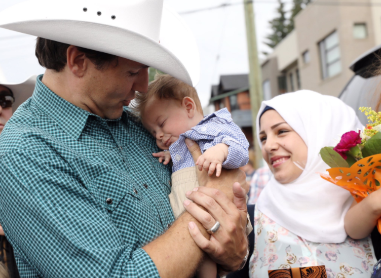 The get-together took place at the Calgary Stampede where the baby snoozed contently while Mr Trudeau held him: Twitter