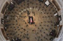 <p>Lewis lies in state at the center of the U.S. Capitol Rotunda. The late congressman is the first Black lawmaker to have the honor of lying in state there. In light of the COVID-19 pandemic, attendees had to wear masks and seats were spread out to comply with social distancing requirements. In this aerial photo, members of the Congressional Black Caucus gathered to touch the casket.</p>