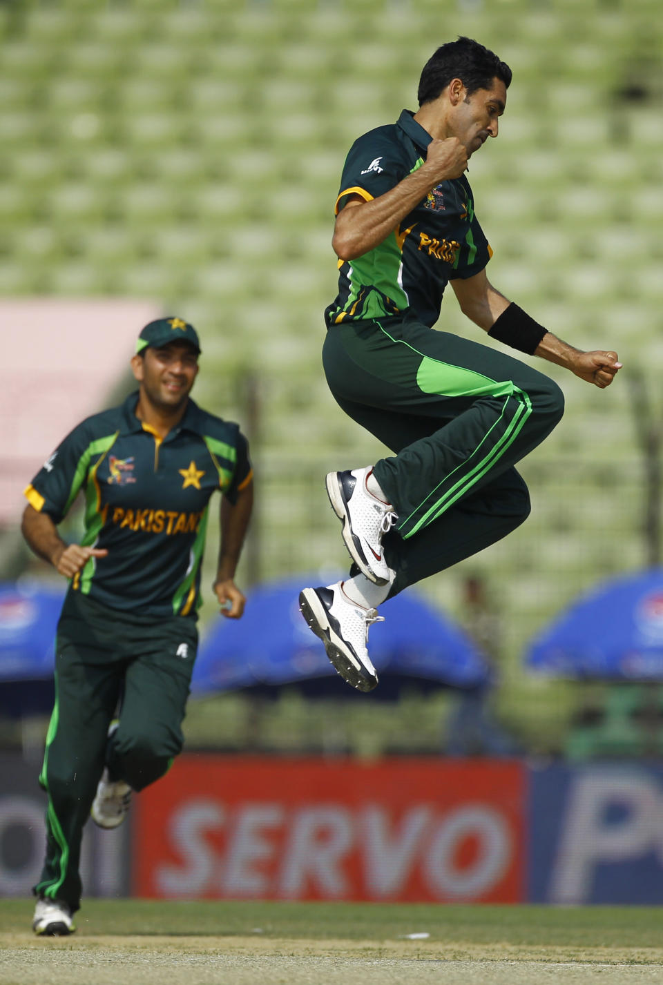 Pakistan's Umar Gul jumps to celebrate the wicket of Sri Lanka’s Kusal Perera during the opening match of their Asia Cup one-day international cricket in Fatullah, near Dhaka, Bangladesh, Tuesday, Feb. 25, 2014. (AP Photo/A.M. Ahad)