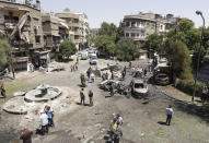 <p>Syrians gather to inspect the damage at the site of a suicide bomb attack in the capital Damascus’ eastern Tahrir Square district, on July 2, 2017. (Louai Beshara/AFP/Getty Images) </p>