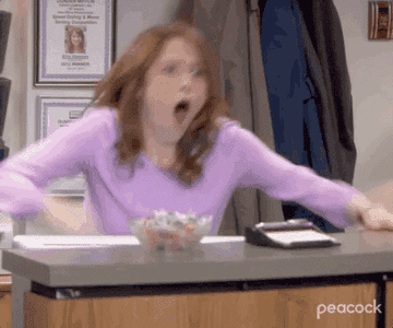 Ellie Kemper in The Office cheering behind a desk