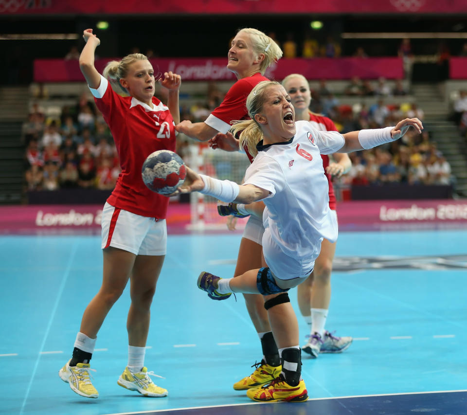 LONDON, ENGLAND - AUGUST 03: Heidi Loke #6 of Norway shoots past Ann Grete Norgaard (L) #23 and Rikke Skov #25 of Denmark during the Women's Handball Preliminaries Group A match between Norway and Denmark on Day 7 of the London 2012 Olympic Games at Copper Box on August 3, 2012 in London, England. (Photo by Jeff Gross/Getty Images)