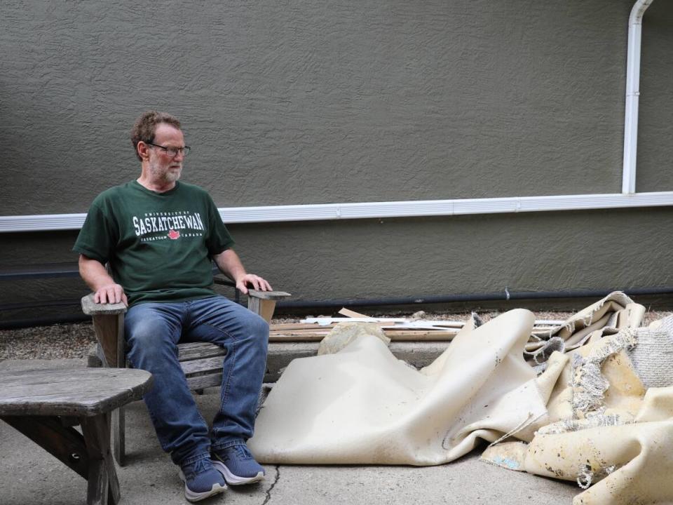 Pius Gartner surveys his ruined basement carpets outside of his flooded home.  (Kendall Latimer/CBC - image credit)