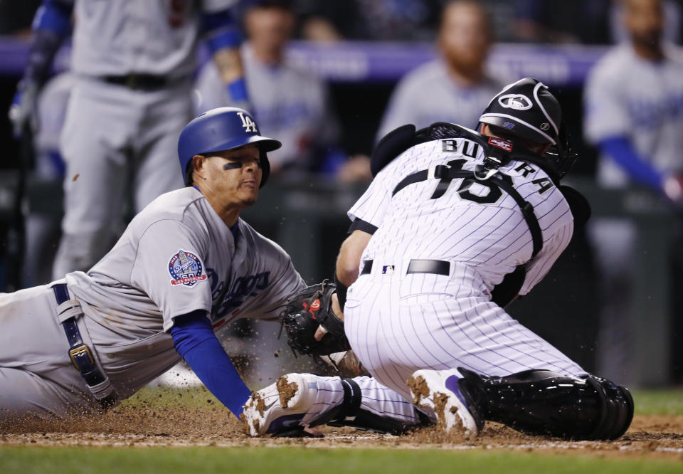 Colorado Rockies catcher Drew Butera, right, tags out Los Angeles Dodgers' Manny Machado who was trying to score from third base on a ground ball hit by Enrique Hernandez in the fifth inning of a baseball game Friday, Sept. 7, 2018, in Denver. (AP Photo/David Zalubowski)