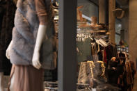 A woman looks at clothes inside a store on Oxford Street in London, Monday, Nov. 29, 2021. Countries around the world slammed their doors shut again to try to keep the new omicron variant at bay Monday, even as more cases of the mutant coronavirus emerged and scientists raced to figure out just how dangerous it might be. In Britain, mask-wearing in shops and on public transport will be required, starting Tuesday. (AP Photo/Matt Dunham)