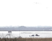 Emergency personnel work at the scene of a plane crash site in Trinity Bay in Anahuac, Texas on Saturday, Feb. 23, 2019. The Federal Aviation Administration said a Boeing 767 cargo plane went down approximately 30 miles southeast of Houston's George Bush Intercontinental Airport. (Brett Coomer/Houston Chronicle via AP)