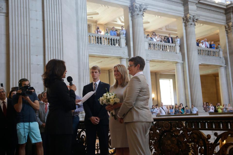 Sandy Stier, center left, and Kris Perry, at right, exchange wedding vows in June 2013 in front of then-California Attorney General Kamala Harris, left, at City Hall in San Francisco. Stier and Perry were the lead plaintiffs in the U.S. Supreme Court case that overturned California's same-sex marriage ban.
