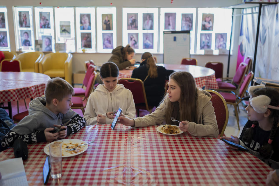 A group of young Ukrainian refugee circus students eating together before the start of their training in Budapest, Hungary, Monday, Feb. 13, 2023. More than 100 Ukrainian refugee circus students, between the ages of 5 and 20, found a home with the Capital Circus of Budapest after escaping the embattled cities of Kharkiv and Kyiv amid Russian bombings. (AP Photo/Denes Erdos)