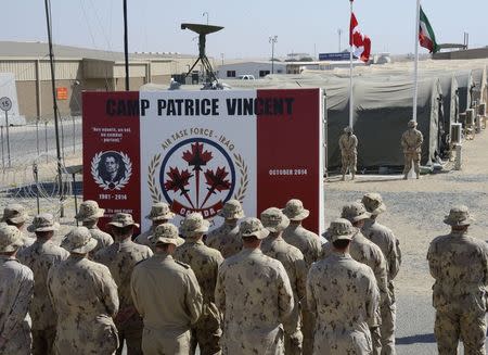 Canadian Armed Forces members stand in front of the new Camp Patrice Vincent commemorative wall at the Remembrance Day ceremony in Kuwait on November 11, 2014, in this handout photo provided by the Canadian Forces. REUTERS/Canadian Forces/Handout