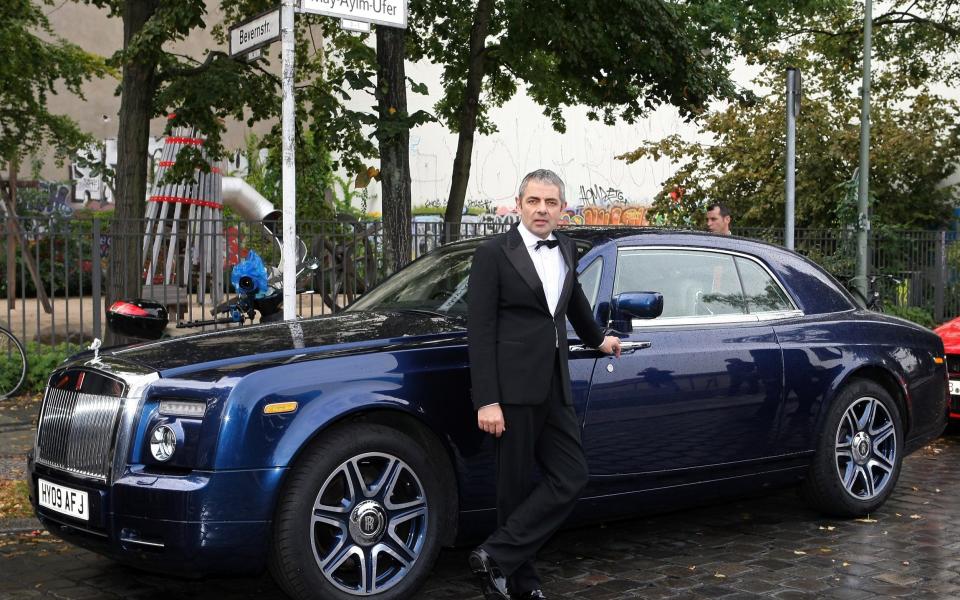 British Actor Rowan Atkinson poses next to a Rolls-Royce automobile on September 27, 2011 in Berlin