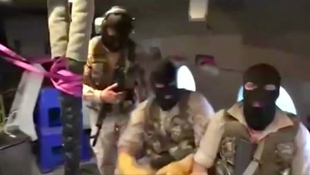 Iranian Revolutionary Guard troops wearing ski masksare seen on board a helicopter flying over British-flagged tanker Stena Impero near the strait of Hormuz