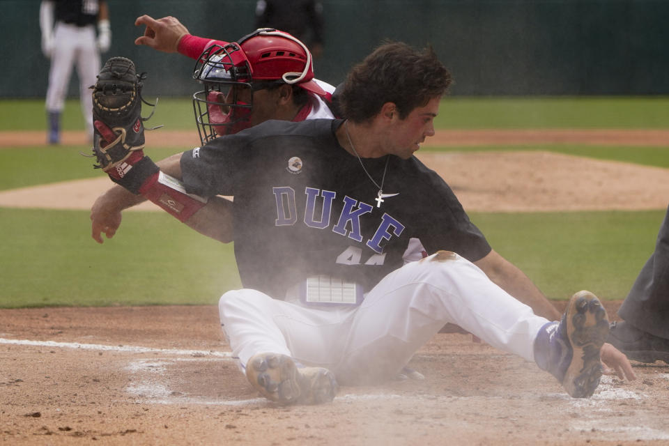 Duke's Graham Pauley, right, is tagged out at home by North Carolina State catcher Luca Tresh trying to score on a double by Joey Loperfido in the third inning of an NCAA college baseball game at the Atlantic Coast Conference championship game on Sunday, May 30, 2021, in Charlotte, N.C. (AP Photo/Chris Carlson)