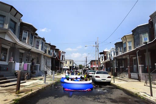 Residents block cars and set up a pool on the street to swim on Wednesday, June 20, 2012, in Philadelphia. Temperatures climbed toward the high 90s along the Eastern Seaboard as an unusually early hot spell heralded the official start of summer. (AP Photo/Brynn Anderson)