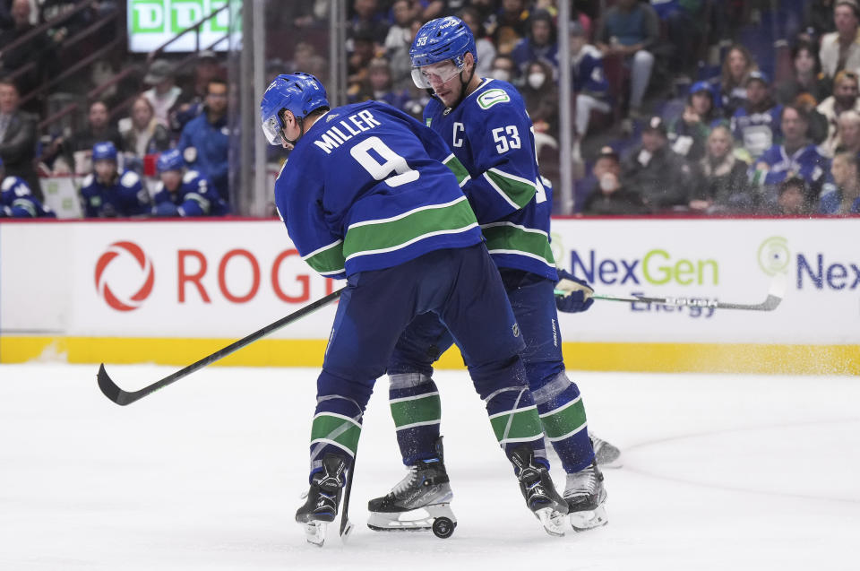 Vancouver Canucks' Bo Horvat (53) and J.T. Miller (9) collide during the third period of an NHL hockey game against the Carolina Hurricanes in Vancouver, British Columbia, Monday, Oct. 24, 2022. (Darryl Dyck/The Canadian Press via AP)