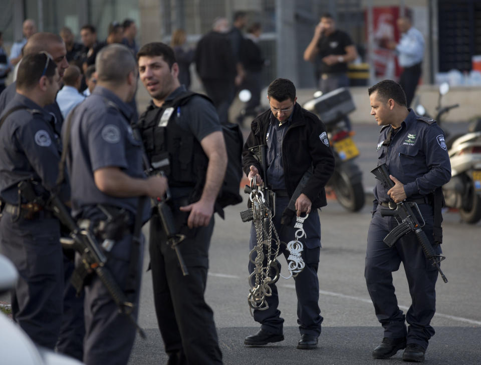 Israeli Prison Service officers stand at the entrance to Sharon Prison while Israeli police SWAT team entered the prison, near Raanana, central Israel, Sunday, Feb. 23, 2014. Israeli police say a SWAT team has killed an inmate who had seized a guard's weapon and shot three guards. Police spokesman Micky Rosenfeld said Sunday that the inmate, who was serving a long sentence for murder, had barricaded himself after shooting the guards. A standoff ensued, with counter-terrorism units dispatched to the scene. The inmate then opened fire again, he said, before the forces shot him dead. Of the three guards shot, two were seriously wounded, thrid was wounded lightly. The prisoner was not officially identified, but Israeli media reports identified him as Samuel Sheinbein, an American who fled to Israel after committing a murder in Maryland in 1997. (AP Photo/Ariel Schalit)