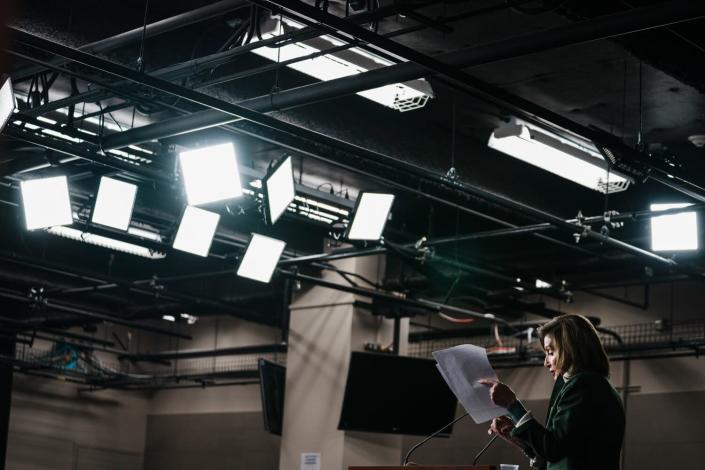 A person looks at papers under bright ceiling lights.