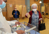 A woman casts a vote at a voting center during the second round of the municipal elections, in Saint Pee sur Nivelle, southwestern France, Sunday, 28, June, 2020. France is holding the second round of municipal elections in 5,000 towns and cities Sunday that were postponed due to the country's coronavirus outbreak. (AP Photo/Bob Edme)