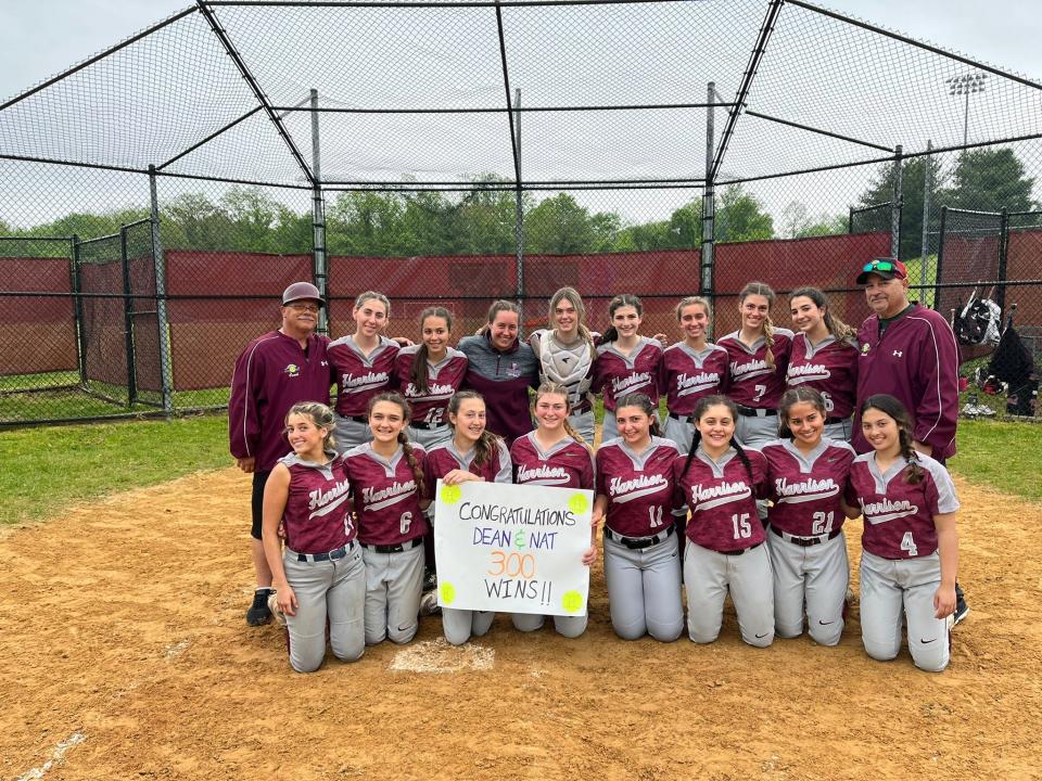 Harrison coaches Dean Marino (on the right end of the back row) and Nat Acuti (left end of the back row) celebrate their 300th win as coaches, after sophomore pitcher Gabriella Triano tossed a perfect game in the Huskies' 17-0 playoff win over Saunders.