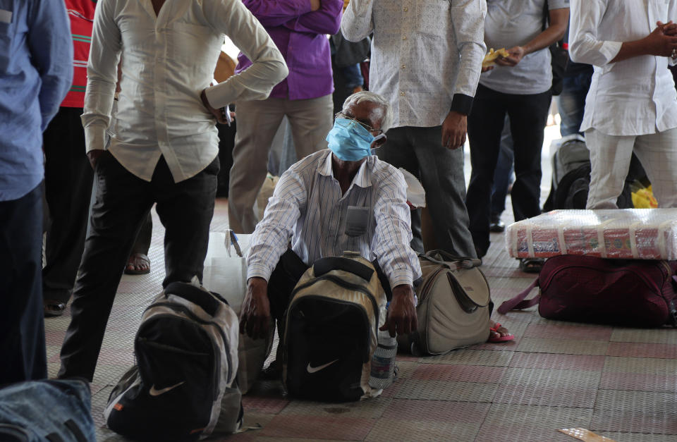 Passengers wait outside Hyderabad Railway Station to catch a train to return to their home states in Hyderabad, India, Monday, June 1, 2020. More states opened up and crowds of commuters trickled onto the roads in many of India's cities on Monday as a three-phase plan to lift the nationwide coronavirus lockdown started despite an upward trend in new infections. (AP Photo/Mahesh Kumar A.)