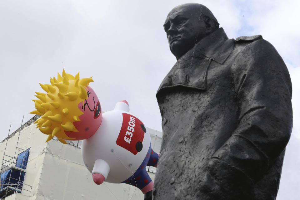 A blimp balloon depicting contender for leadership of Britain's ruling Conservative Party, Boris Johnson is launched outside Parliament, next to a statue of wartime leader Winston Churchill, during an anti-Brexit protest in London, Saturday July, 20, 2019. The pro-European march was organised by the March for Change group. Johnson is a leading Brexit advocate. (Aaron Chown/PA via AP)