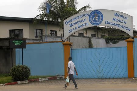 A man walks near a screen displaying a message on Ebola outside the local headquarters of the World Health Organisation (WHO) in Abidjan August 15, 2014. REUTERS/Luc Gnago