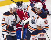 Edmonton Oilers' Dominik Kahun (21) celebrates with teammate Connor McDavid (97) after scoring the third goal against Montreal Canadiens goaltender Jake Allen (34) during second-period NHL hockey game action in Montreal, Monday, May 10, 2021. (Ryan Remiorz/The Canadian Press via AP)