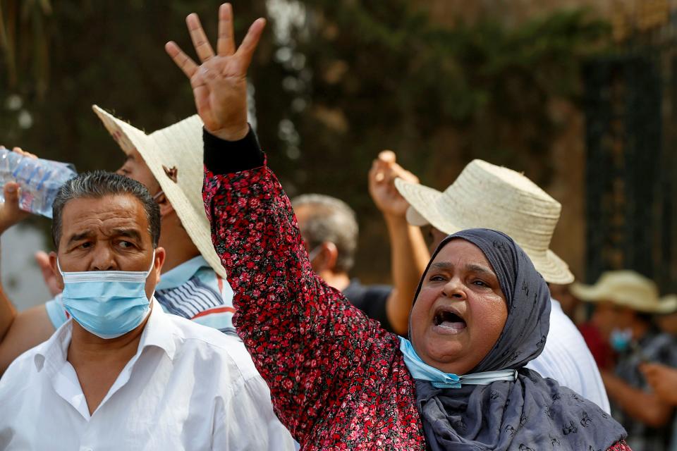 A supporter of Tunisia's biggest political party, the moderate Islamist Ennahda, gestures outside the parliament building in Tunis (REUTERS)