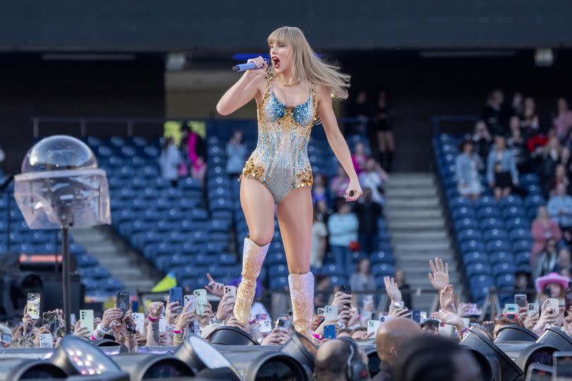 Taylor Swift performing on stage at Murrayfield in a blue and gold bodysuit